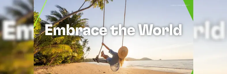A lady on a swing at the beach with 'Embrace the World' written above