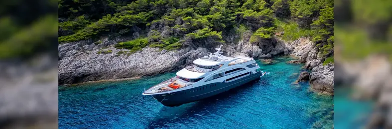 Unforgettable Croatia ship in an alcove in the blue sea with rocky vegetation surrounding