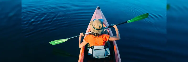 Person kayaking alone in blue waters