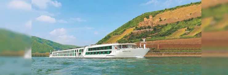 A luxury Scenic Group ship cruising down a river