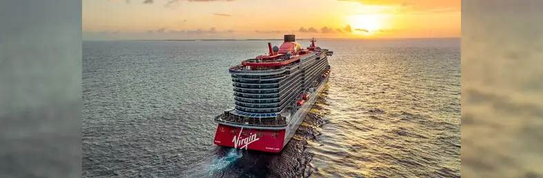 Virgin Voyages' Scarlet Lady sailing off into the sunset