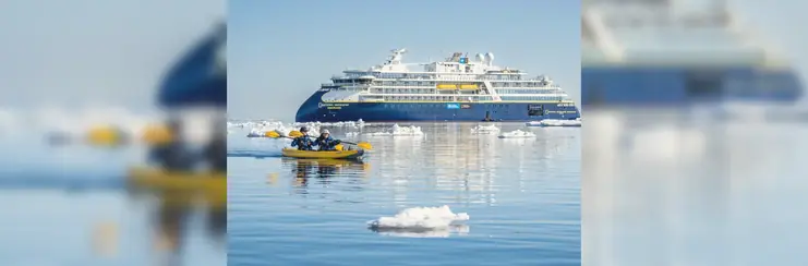 An expedition cruise in Norway, with two people kayaking amongst ice.