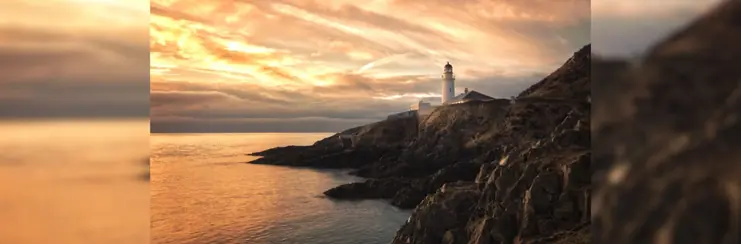 The coast of the Isle of Man, during sunset with a lighthouse in the background