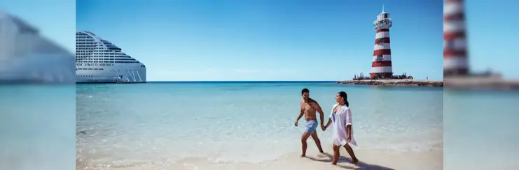 Couple walking on a beach with a lighthouse to the right and an MSC Cruises ship to the left