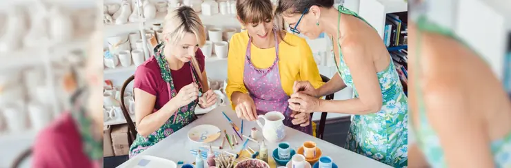 Three women partaking in pottery painting