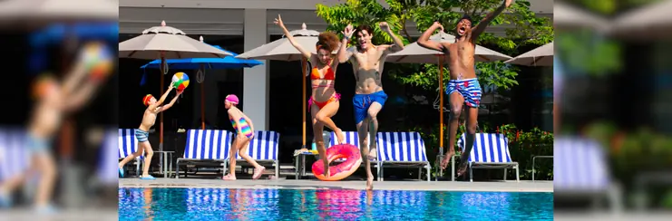 A woman and two men jump into an OZO pool