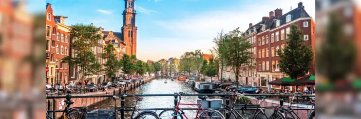 Amsterdam canal with bikes leaning against railing