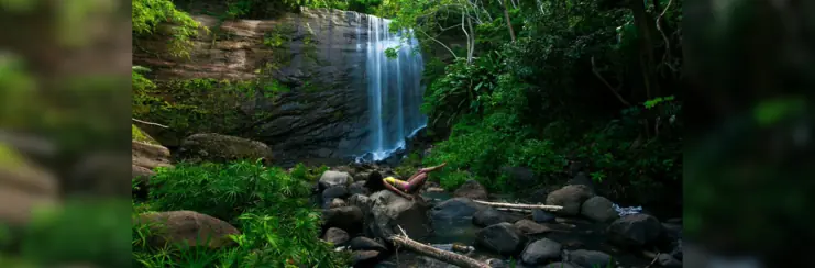 Mt Carmel waterfall with woman lying on rocks in front of it