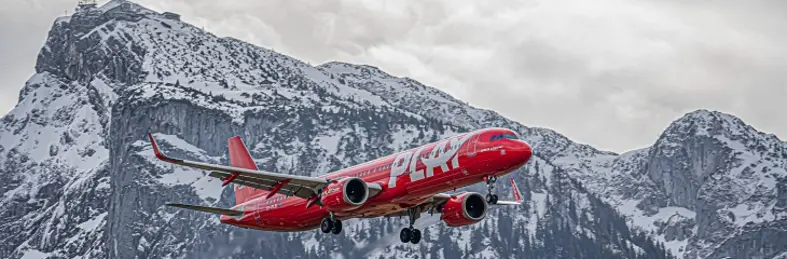 PLAY plane flying in snowcapped mountains