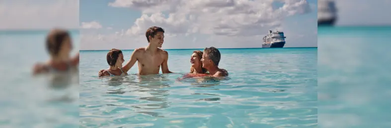 Image of a family enjoying their time in the Caribbean waters with a Holland America vessel in the background. 
