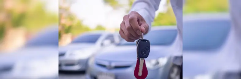 Person dangling the keys to a hire car.