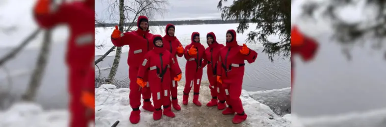 A group of travel agents in winter gear holding their thumbs up in Lapland